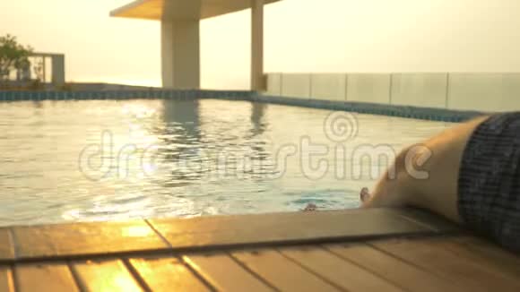 那人坐在池边双脚在水中房子屋顶上的豪华游泳池和一个视频的预览图