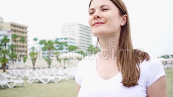 年轻女子独自沿着海滩散步从地中海吹来的风慢慢地吹着她的头发视频的预览图