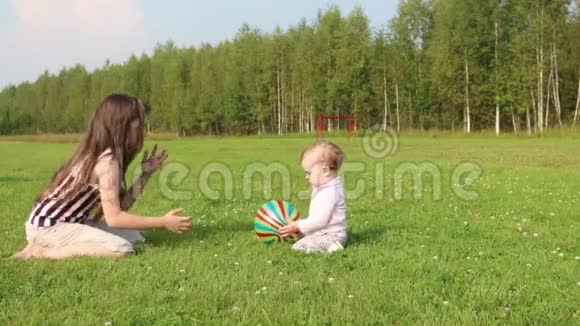 女孩在绿野上玩宝宝和球视频的预览图