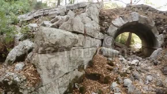 女孩进入被毁的拱形入口全景在古色古香的奥林匹亚城废墟中巨大的石头毁坏了罗马剧院视频的预览图