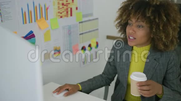 在使用电脑时喝咖啡的年轻工人视频的预览图