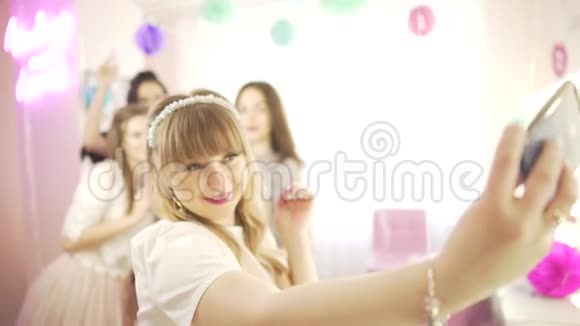 年轻快乐兴奋迷人的金发女郎与女友拍自拍手机照片背景视频的预览图