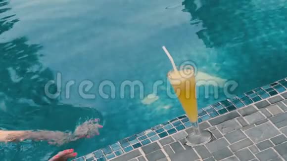 年轻女子在游泳池里喝鸡尾酒视频的预览图