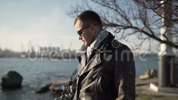 寒冷的阳光下白人摩托车手在港口附近戴着头盔视频的预览图