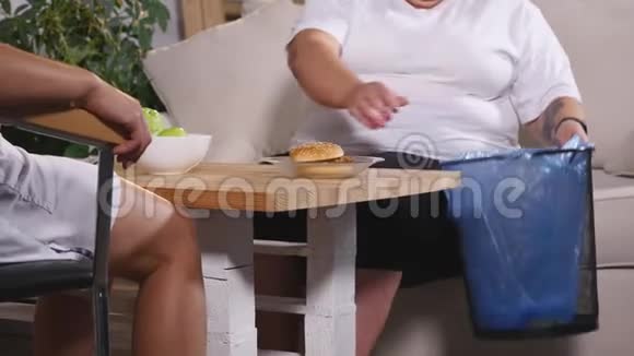 一个胖女人从垃圾桶里拿出一个汉堡视频的预览图