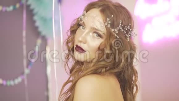 年轻漂亮的红发女郎戴着珍珠头在美容院的摄像机前摆着姿势视频的预览图