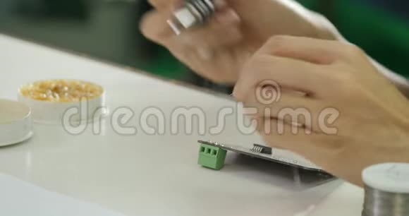 亚洲电子工程师正在他的车间焊接一块电电板视频的预览图