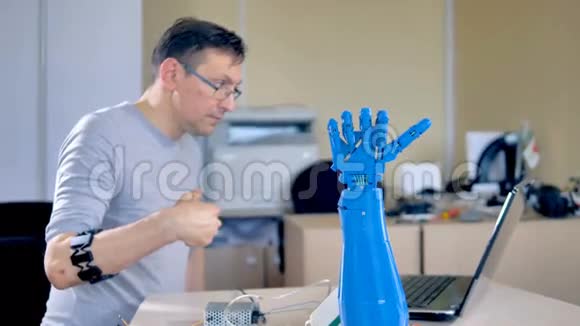 一位工程师测试一只蓝色的机器人手视频的预览图