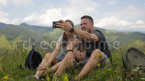 年轻的一对游客在山上自拍视频的预览图