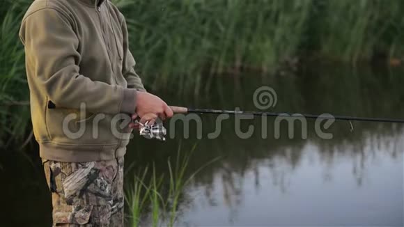 鱼人在春天在湖边钓鱼孤独的垂钓者独自生活在大自然的包围中他休息一下视频的预览图