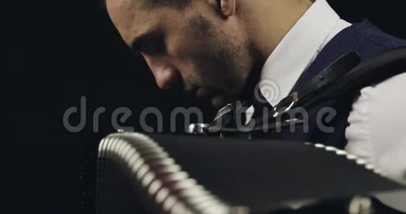 手风琴穿着白色衬衫和灰色领带录音室黑人背景的音乐家视频的预览图