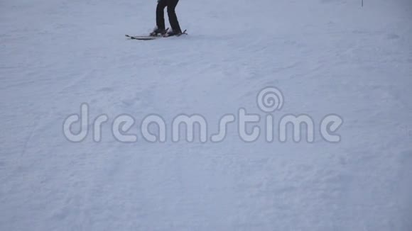 一双面目全非的女滑雪者在山上的雪坡上降下来在滑雪场滑下山的年轻女孩视频的预览图