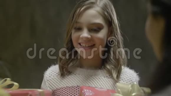 微笑女孩从父母手中接过家庭圣诞箱视频的预览图
