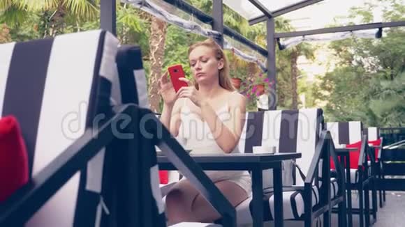 年轻的女人坐在咖啡馆的桌子上看着电话不高兴的分手4k慢动作时尚咖啡厅内部视频的预览图