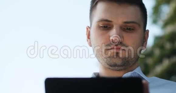 微笑男商人律师医生经理程序员办公室工作人员用他的垫子在街上的平板电脑上视频的预览图