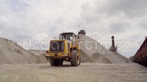 一台大挖掘机帮助将碎石装入火车车厢视频的预览图