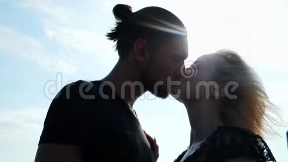 爱的一对情侣在夕阳下接吻在空气中相爱在阳光下浪漫的一对情侣接吻视频的预览图