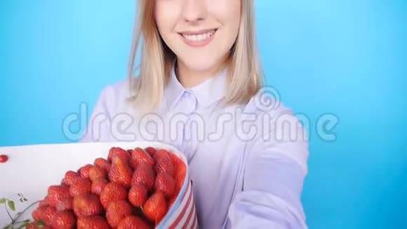 年轻女子拿着一束草莓拍照视频的预览图