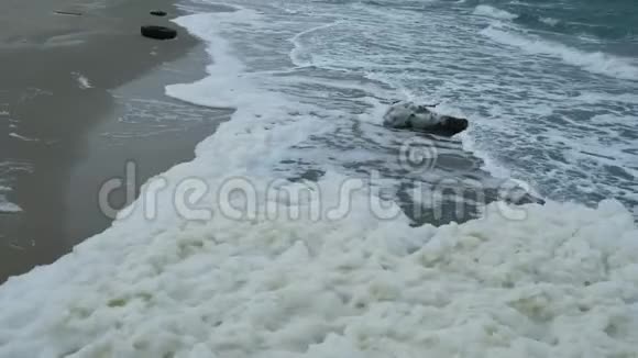 近景的暴风雨波浪沿着海岸移动肮脏的海沫视频的预览图