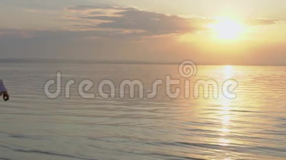 年轻的幸福夫妇在日落时走在海边爱的概念视频的预览图