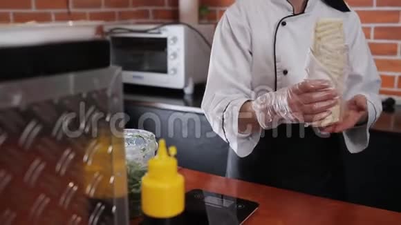 女厨师报告准备沙瓦玛客户特写人手视频的预览图