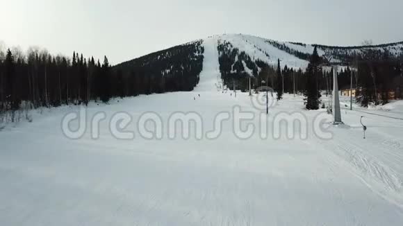 人们在滑雪板和滑雪板上滑到山上视频的预览图