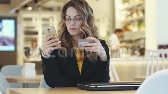 商务女性发送信用卡号码一个穿着西装的女孩在网上购买视频的预览图