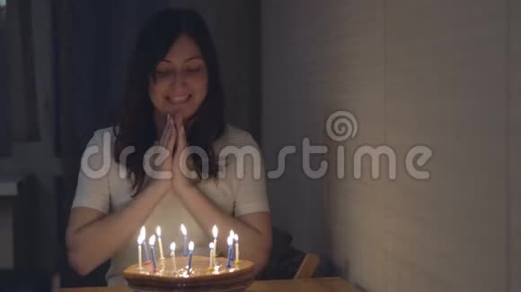 美丽的女人在节日蛋糕上吹蜡烛视频的预览图