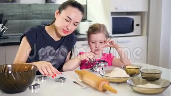母亲给小女儿切饼干慢动作特写镜头高清视频的预览图