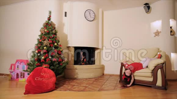 良好的新年精神圣诞树礼品袋壁炉爸爸和女儿扮演傻瓜圣诞老人视频的预览图