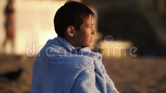 男孩在海边用毛巾取暖视频的预览图