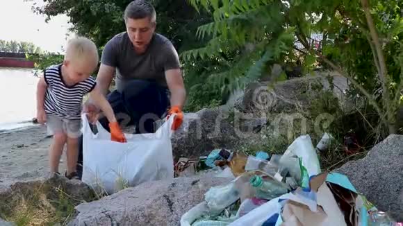 一个小孩子在海滩上收集垃圾他爸爸用手指指着哪里扔垃圾父母教孩子清洁视频的预览图