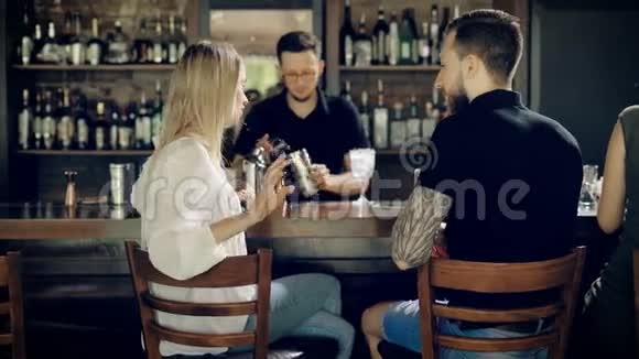 在酒吧里说话坐在酒吧后面的男人和女人视频的预览图