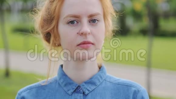 年轻尴尬的红头发女人戴着牙套在户外微笑视频的预览图