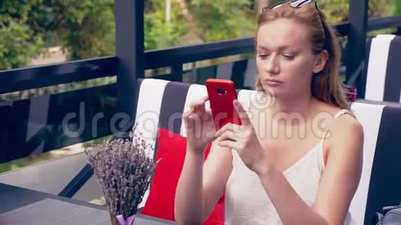 年轻的女人坐在咖啡馆的桌子上看着电话不高兴的分手4k慢动作时尚咖啡厅内部视频的预览图