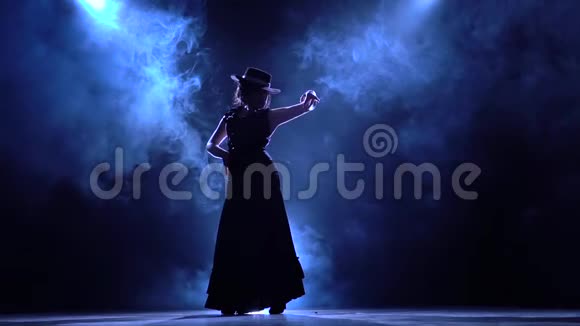 弗拉门戈穿着别致裙子的女人会跳一支燃烧的舞蹈从后面发光烟雾背景剪影慢慢视频的预览图