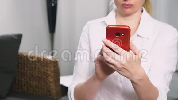 年轻严肃女人的肖像在晚上和使用智能手机与触摸屏视频的预览图