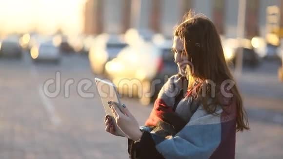 在阳光明媚的城市街道上漂亮的Tung女孩通过垫子与某人交流视频的预览图