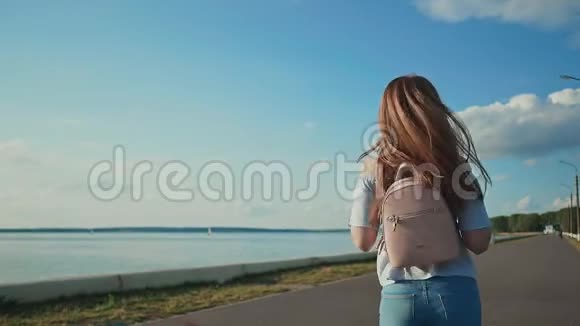 一个背着背包的女学生放学后在河堤上散步视频的预览图