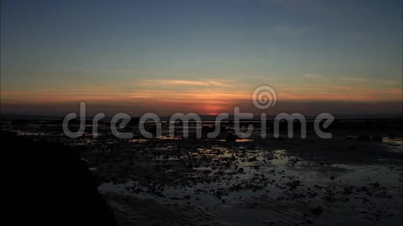 日落时分在一片广阔的海滩上视频的预览图