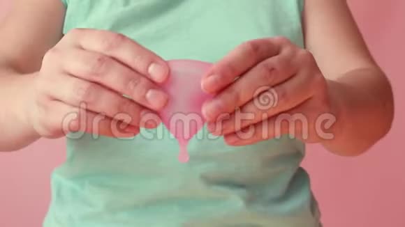 女人手拿可重复使用的硅胶月经杯零浪费月经概念视频的预览图