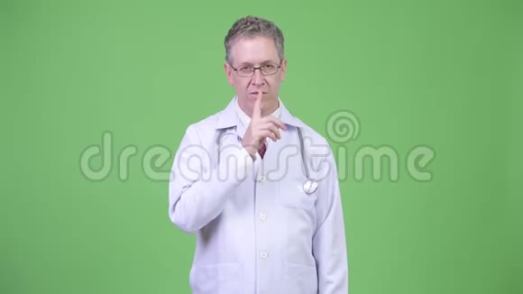 一副成熟的男医生的画像手指在嘴唇上视频的预览图