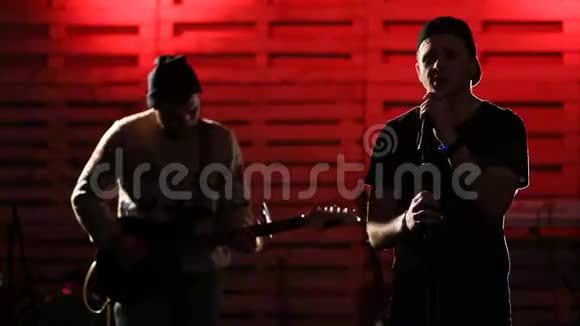 年轻的帅哥和吉他手一起唱歌视频的预览图