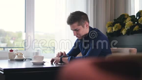 那个拿着智能手表的人坐在咖啡馆里多莉肖像4K视频的预览图