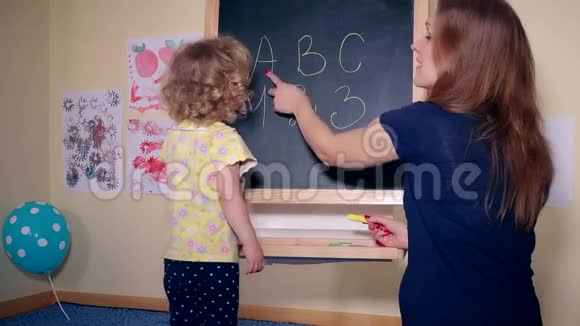 细心的女老师教聪明的孩子字母和数字视频的预览图
