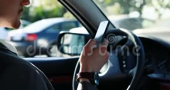 在路上充满自信年轻男子坐在他新买的汽车上智能手机共空间保险安全驾驶视频的预览图