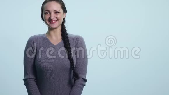 幸福美丽的女人看着隔离在白色背景上的相机穿着白色休闲服的年轻女子满意视频的预览图