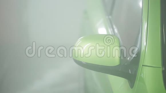 在专用房间内用水和泡沫冲洗汽车的过程用手洗的绿色汽车用喷水冲洗视频的预览图