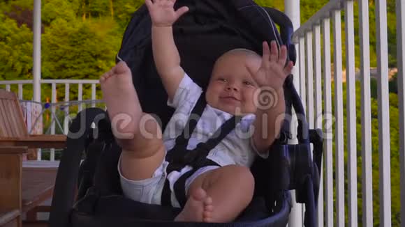 快乐的婴儿在婴儿车上挥舞着手视频的预览图