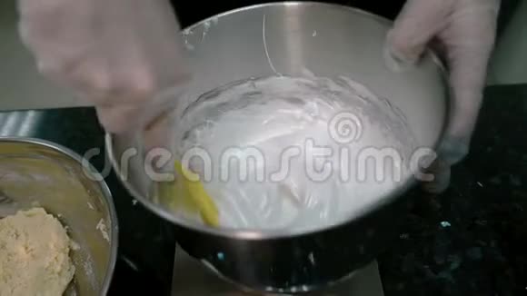 厨师用铲子把蛋白质混合物和面团混合在碗里视频的预览图